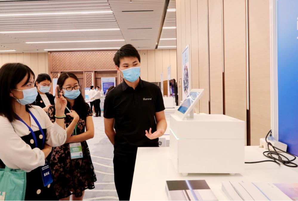 第四屆進(jìn)博會(huì)食品及農(nóng)產(chǎn)品展區(qū)、醫(yī)療器械及醫(yī)藥保健展區(qū)展前供需對(duì)接會(huì)的工作人員在介紹一臺(tái)測(cè)序儀展品