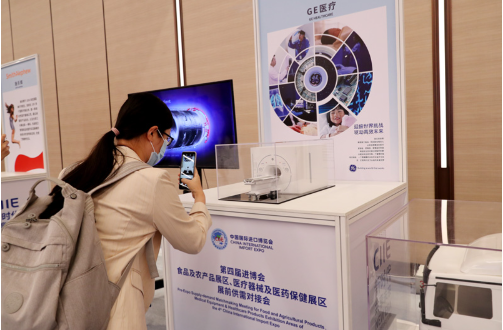 第四屆進(jìn)博會(huì)食品及農(nóng)產(chǎn)品展區(qū)、醫(yī)療器械及醫(yī)藥保健展區(qū)展前供需對(duì)接會(huì)的參會(huì)嘉賓用手機(jī)拍攝參展企業(yè)的展品模型